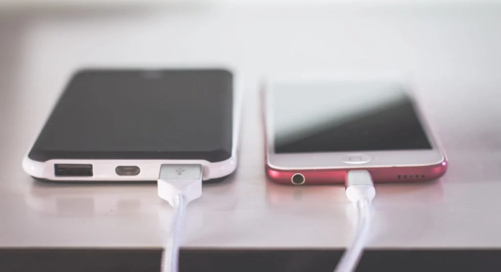 A power bank charging a smartphone