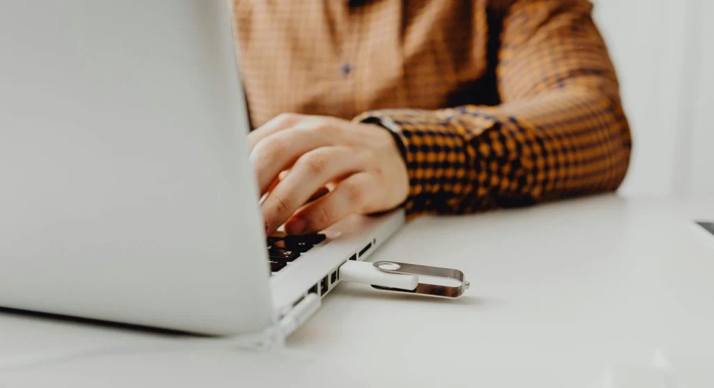 A person safely ejecting a USB flash drive from a computer