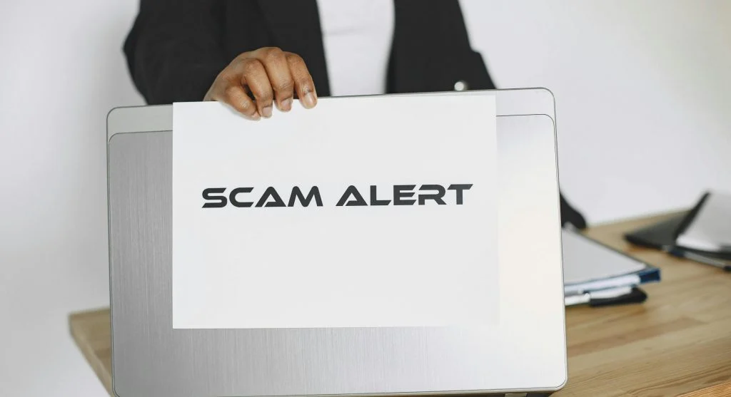 Photo of a person holding a phone with a suspicious message on the screen
