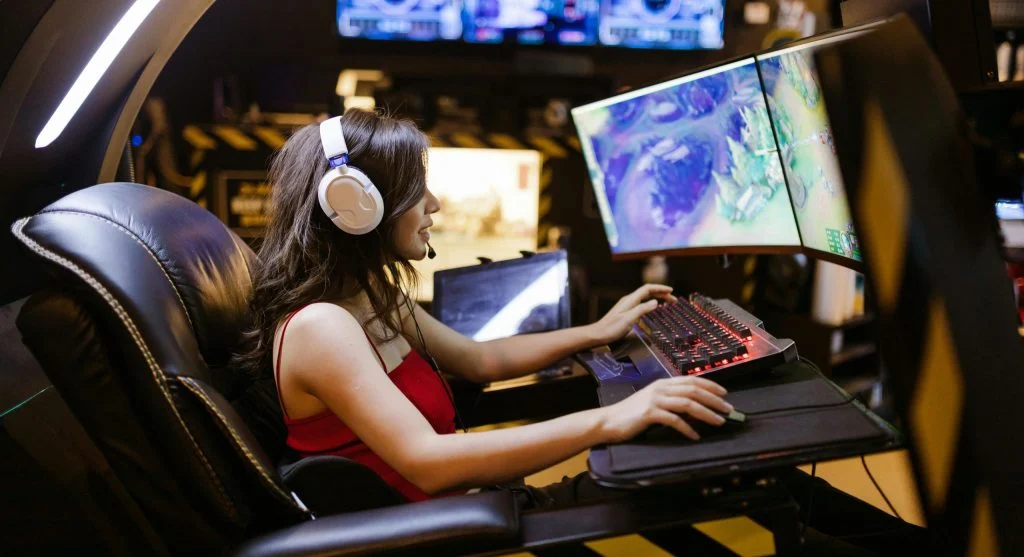 Gamer sitting in front of a computer with a properly positioned monitor and good posture